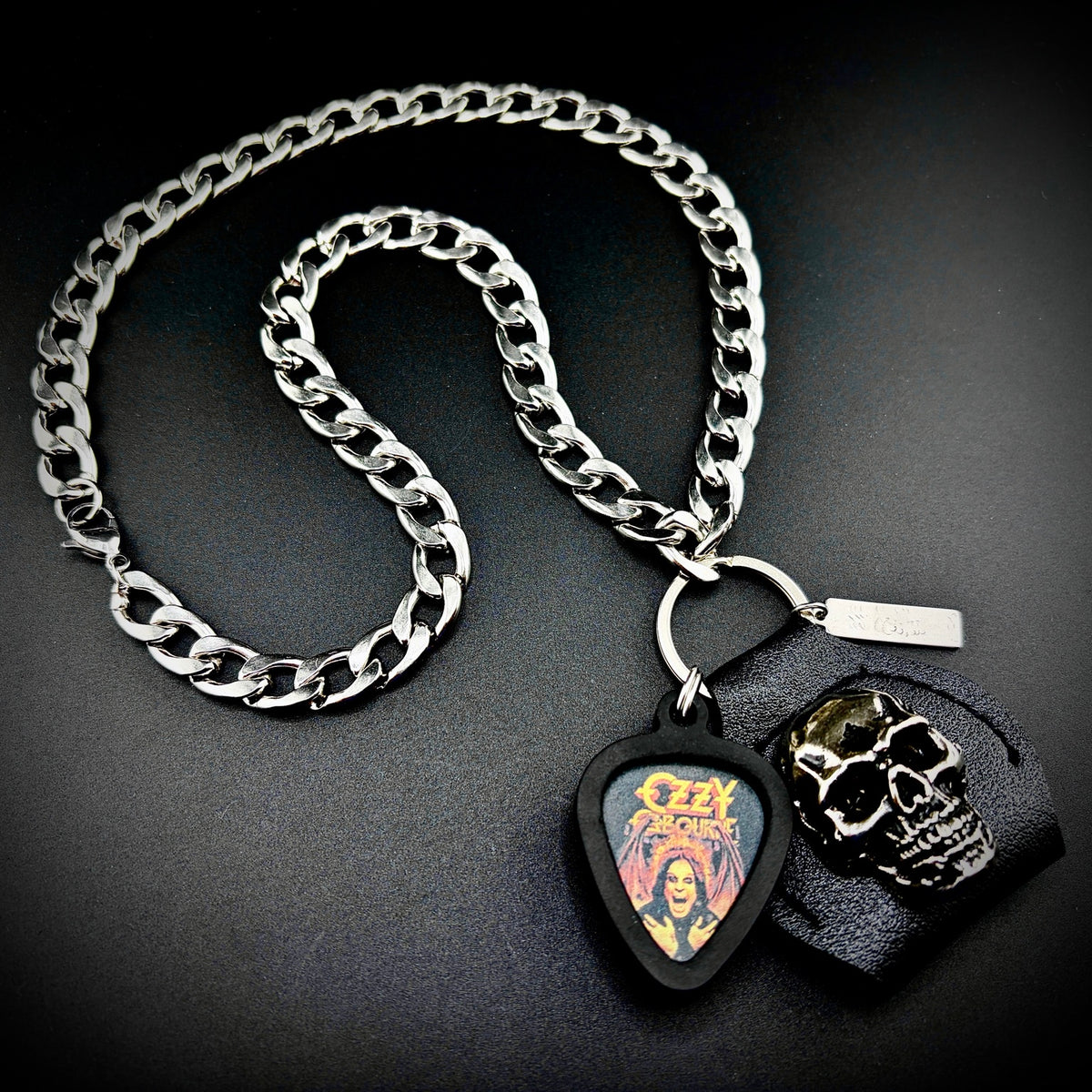 OZZY OSBOURNE RED PORTRAIT guitar pick pendant necklace with silver curb chain and skull holder by SKULL & CHAIN. For fans of Ozzy Osbourne.